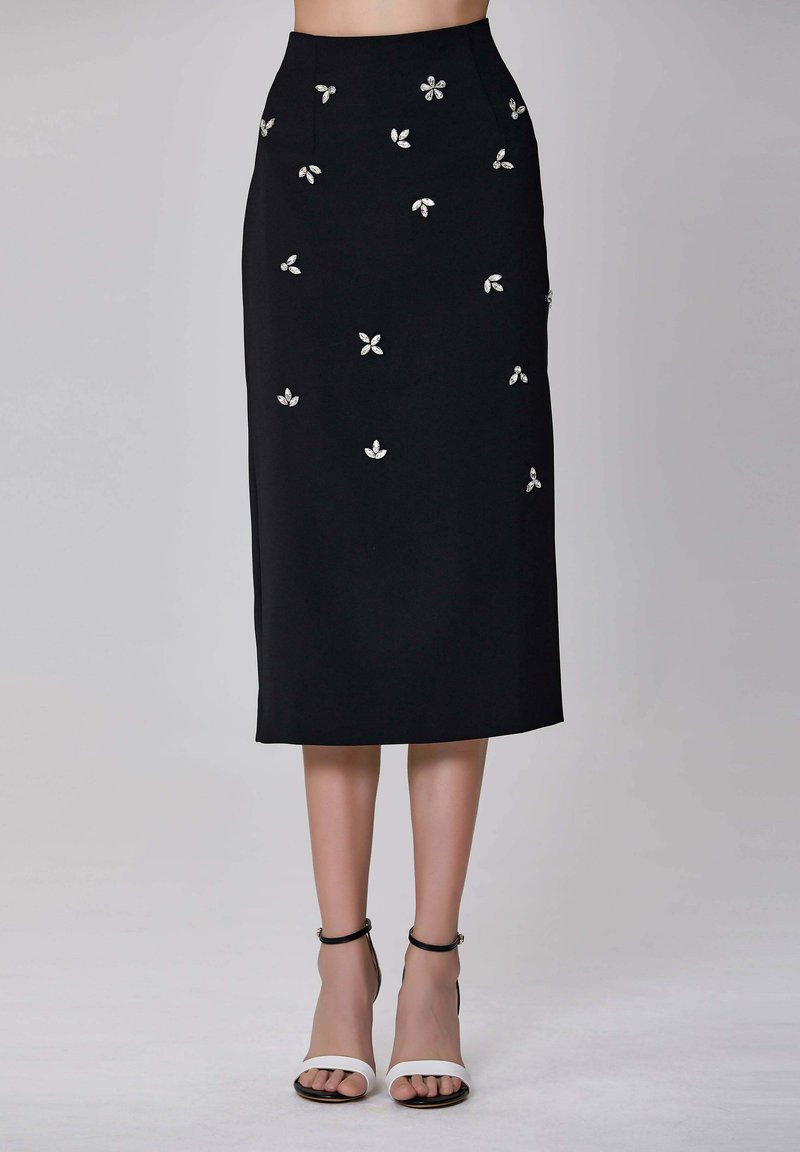 Jupe mi-longue noire avec des embellissements floraux argentés. Conception structurée avec une coupe droite et une texture de tissu lisse.