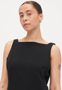 Črna brezrokavna obleka z kvadratnim izrezom, gladkim materialom in subtilnimi šivi na straneh. Minimalističen dizajn z elegantno silhueto.