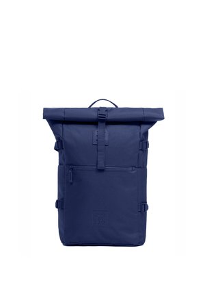 Zaino roll-top blu navy con tasca anteriore con cerniera, cinturini di compressione laterali e chiusura superiore con fibbia, in piedi su sfondo bianco.