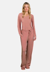 Gestreepte lounge set in rood en beige, met een langslavige top met V-hals en broek met koord in de taille en zakken. Zacht materiaal.