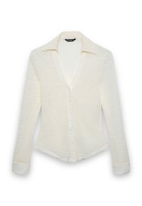 Weißes Langarmhemd mit strukturiertem Muster, frontaler Knopfleiste und Kragen. Es hat eine figurbetonte Silhouette und zulaufende Ärmel.