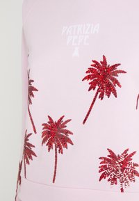 Tissu rose clair avec des motifs de palmiers rouges en sequins et la marque "PATRIZIA PEPE" en texte blanc près du centre supérieur.