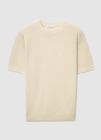 Pull à manches courtes et col rond en beige clair, présentant un motif tricoté texturé et des poignets et ourlet côtelés.