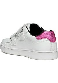 Sneaker bianca con due cinturini velcro regolabili, fodera interna nera e un accento rosa lucido sul tallone. Suola testurizzata per aderenza.