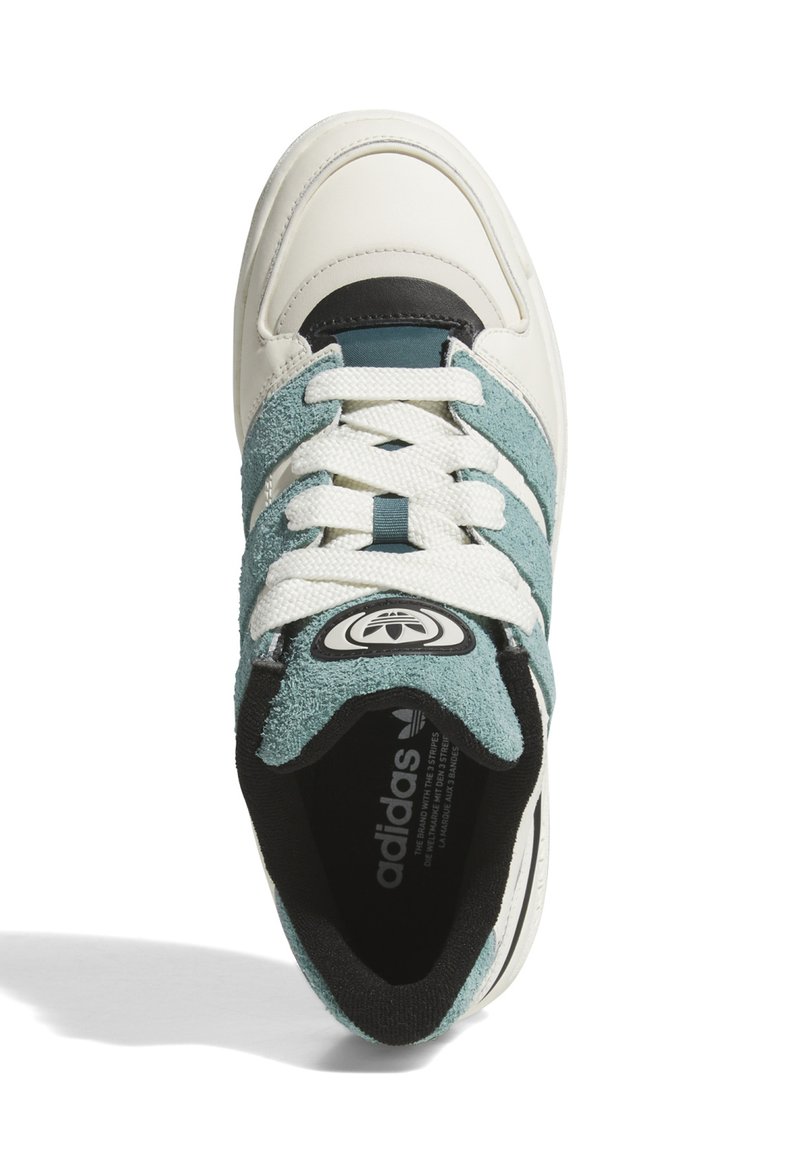 Baskets avec une base en cuir blanc, des accents en suède et toile teal, une languette noire et un patch rond. Présente des rayures texturées et des lacets plats.