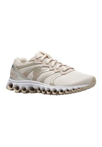 Zapatillas deportivas beige con parte superior de malla texturizada, suela acolchada con recortes circulares y sutiles detalles de marca en acentos metálicos.