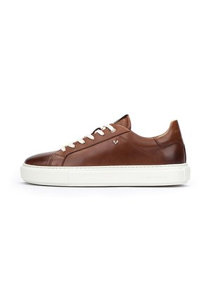 Baskets en cuir marron avec semelle en caoutchouc blanc, design à lacets, surface texturée et accent de branding subtil sur le talon.