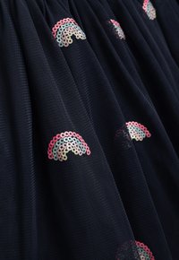 Marinefarbene Tüllröcke mit mehrfarbigen Pailletten-Regenbogenmustern. Der Stoff hat ein weiches, strukturiertes Aussehen mit gathered Details.