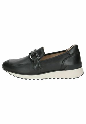 Scarpe slip-on in pelle nera con punta arrotondata, accessori decorativi e suola in gomma bianca con un motivo di battistrada testurizzato.