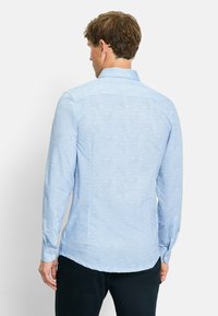 Himmelblause langärmlige Hemd mit einem dezenten Muster, Knopfmanschetten, Kragen und abgerundetem Saum; aus einem glatten Stoff gefertigt.