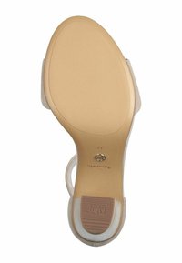 Tan sole with a textured surface, featuring a clear strap. The heel is approximately 3 inches high, marked with "Anti Slide." Brand name visible.
