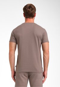 Korte mouwen, bruine katoenen t-shirt met een gestructureerd, geribbeld ontwerp, voorzien van een ronde hals, zichtbare stiksels en een klein zijlabel.