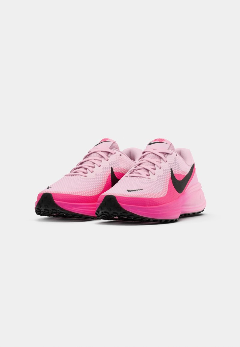 Zapatillas atléticas rosas de material de malla con un swoosh negro, una entresuela rosa, suela texturizada y cordones para un ajuste seguro.
