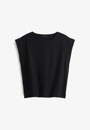 Haut noir à manches courtes avec un col rond. Tissu doux avec des accents brodés texturés sur les épaules. Coupe décontractée, sans fermetures.