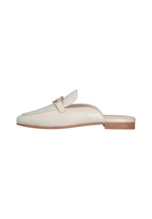 Mules de cuero beige sin talón con punta redondeada, tacón de madera plano y una hebilla de acento en tono dorado en el empeine. Textura suave.