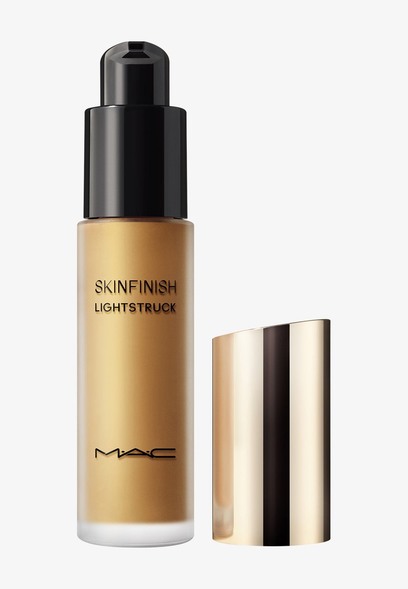 Bottiglia di fondotinta liquido MAC Skinfinish Lightstruck con pompa nera e cappuccio dorato lucido, posizionata accanto su uno sfondo bianco.