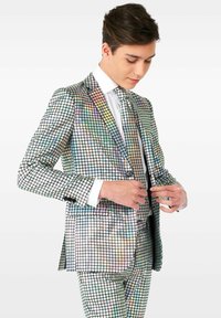 Traje brillante y multicolor hecho de material reflectante con un patrón de cuadrícula; incluye una camisa blanca y una corbata a juego.