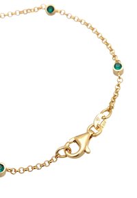 Bracciale in oro con quattro pietre di turchese, un robusto gancio a moschettone e una finitura riflettente. Include dettagli di punzonatura vicino al gancio.