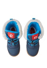 Blauwe winterlaarzen met witte nepbontvoering, rubberen zolen en elastische veters. Heeft een rood logo-label op de kraag en contrasterende texturen.