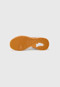 Semelle de chaussure de sport blanche avec une semelle extérieure en caoutchouc orange. Présente des motifs de grip texturé et un élément de design circulaire près du talon.