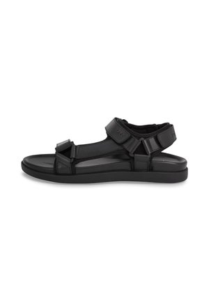 Sandalia negra de punta abierta con correas ajustables de Velcro sobre el tobillo y los dedos, suela acolchada, diseñada para uso casual.