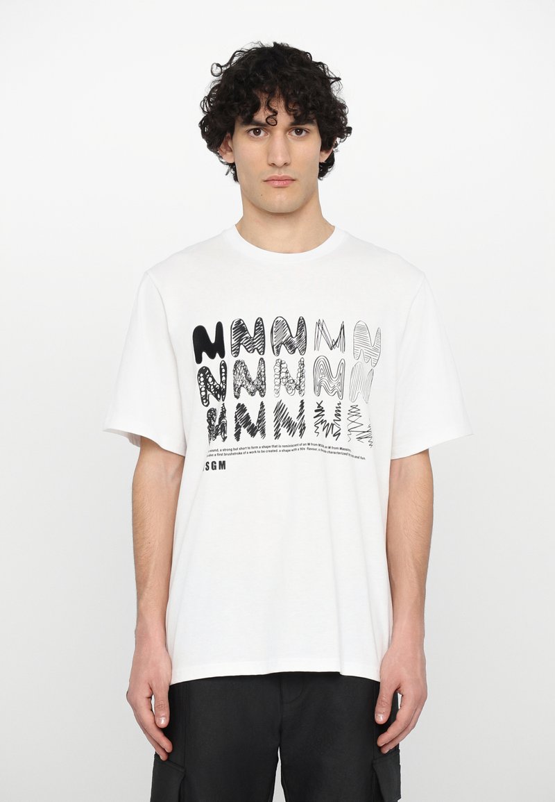 T-shirt in cotone bianco con un design grafico caratterizzato da lettere di forme diverse in tonalità di nero e grigio. Maniche corte e vestibilità rilassata.