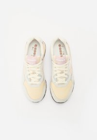 Lysfargede sneakers med en blanding av mesh og semsket skinn, med rosa detaljer og perforert tekstur. Snøringene er beige.