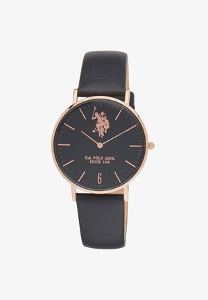 Montre noire avec un boîtier rond en ton or, dotée d'un cadran noir, de marqueurs horaires en or rose et d'un bracelet en cuir noir. Le marqueur de six heures est mis en évidence.