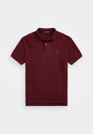 Polo bordeaux en coton texturé, avec un col classique, deux boutons et un petit logo brodé sur la poitrine gauche.