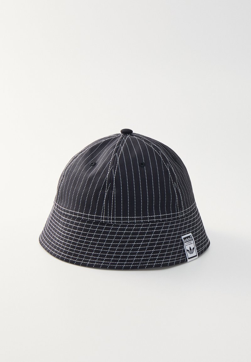Svart bucket hat med vit randig mönster, mjukt tyg och en broderad logotyp på sidan. Mellanlång skärm och rund krona.