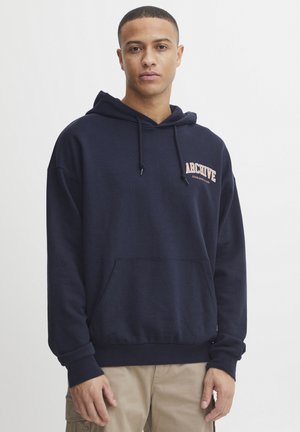 Marineblå hætte sweatshirt lavet af blød bomuld, med en frontlomme og "ARCHIVE" logo i orange. Ribbenkantsærmer og -bund.