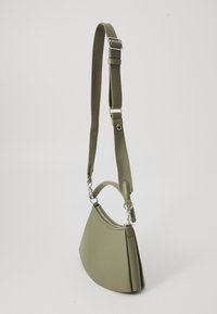 Green, semi-structured handbag with a rounded triangular shape, featuring a top handle and adjustable strap. Smooth material with silver hardware.