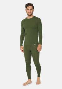 Grøn langærmet termotop og matchende leggings lavet af blødt, strækbart stof. Har et tætsiddende design uden synlige mønstre.