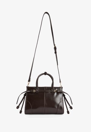 Mørkebrunt læderhandbag med en struktureret design, tophåndtag og en justerbar crossbody-strop. Har guldfarvet hardware og sidefringe.