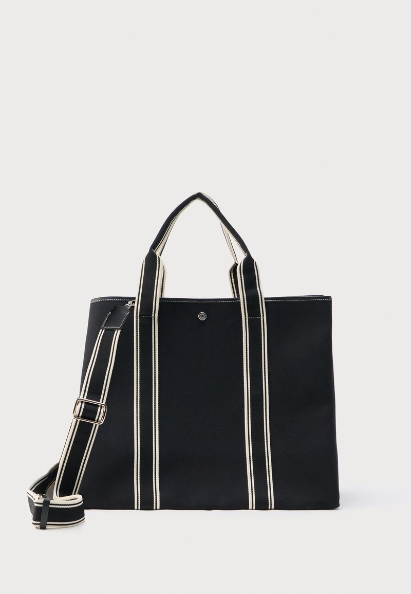 Μαύρη τσάντα ώμου με δύο κοντά χερούλια και αφαιρούμενο ριγέ λουράκι ώμου, με κάθετες λευκές ρίγες.