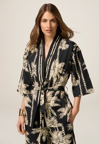 Czarny kimono z wzorem palm w odcieniu kremowym, z szerokimi rękawami, dopasowaną talią i ozdobnymi koralikami wzdłuż dekoltu.