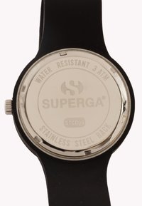 Black silicone watch strap with a stainless steel back. Features marking "WATER RESISTANT 3 ATM" and "SUPERGA®" logo. Circular design.