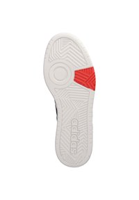 Sola di sneaker bianca con motivi testurizzati, logo Adidas prominente e un accento rosso a forma triangolare.
