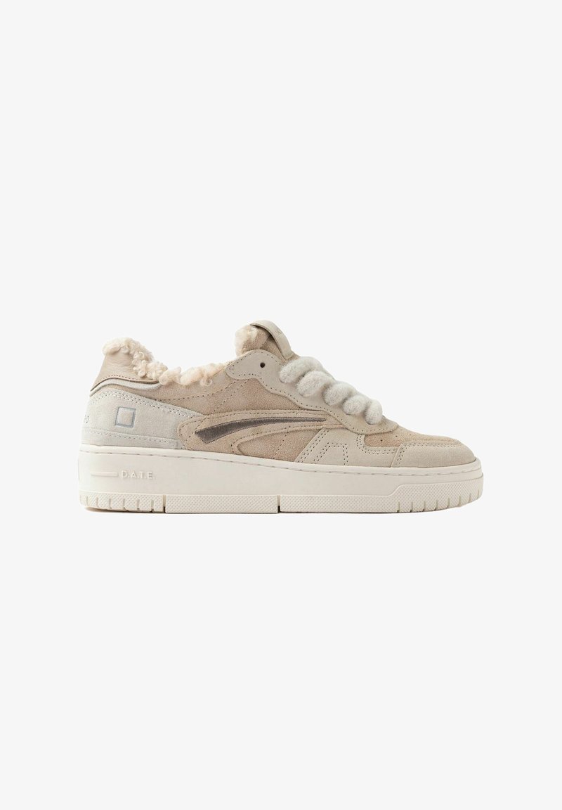 Sneaker in suede beige con una finitura testurizzata, che presenta dettagli in peluche attorno al colletto, lacci spessi e una suola in gomma stampata.