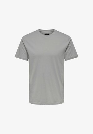Siva majica s okroglim ovratnikom, narejena iz mehkega bombaža, z kratkimi rokavi in sproščenim krojem. Brez vidnih logotipov ali vzorcev.