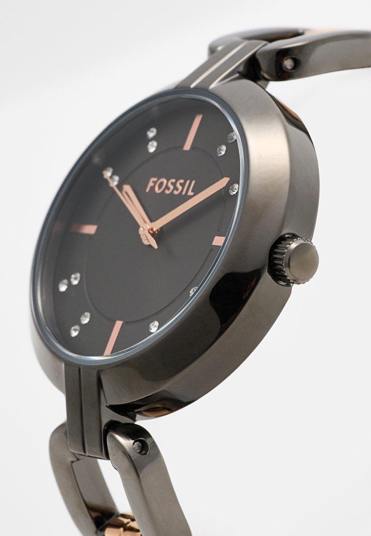 Montre Fossil noire avec un cadran rond, accents argentés, aiguilles en or rose et marqueurs en cristal, dotée d'un bracelet en métal poli et d'une couronne.