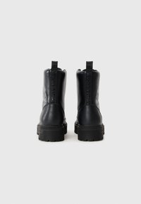 Musthave nahkasaapad, millel on tekstuurne viimistlus, paks kummitald ja reljeefne bränding seljaosas. Mugavaks lisamiseks tõmblukud.