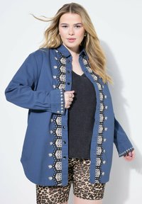 Modrá košile na knoflíky s černým a krémovým vyšitým detailem vpředu, spárovaná s leopardím potiskem.