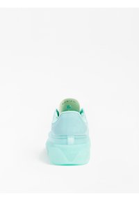 Miętowo-zielony sneaker wykonany z gładkiego materiału, o zaokrąglonym kształcie i grubej, przezroczystej podeszwie. Lekka konstrukcja z wyściełanym kołnierzem i detalem z logo.