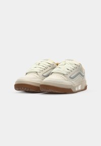 Beige sneakers med grå detaljer, laget av semsket skinn og mesh-materialer, rund tå, snøring, og en teksturert gummi såle.