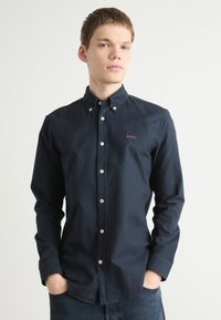 Mariniershemd met een slim fit, van katoenen materiaal, witte knopen en een klein rood "BOSS" logo op de linkerborst.