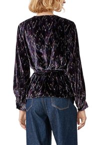 Blusa in velluto con un motivo viola scuro e multicolore, maniche lunghe e vita stretta. Texture liscia e vestibilità rilassata.