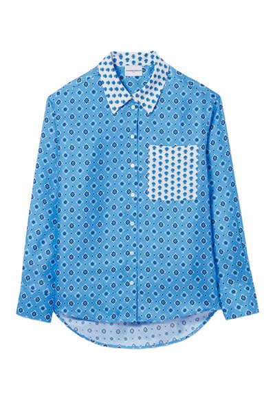 Camicia a maniche lunghe azzurro chiaro con motivo floreale, tasca bianca in contrasto, colletto a punta e orlo arrotondato. Realizzata in tessuto morbido.