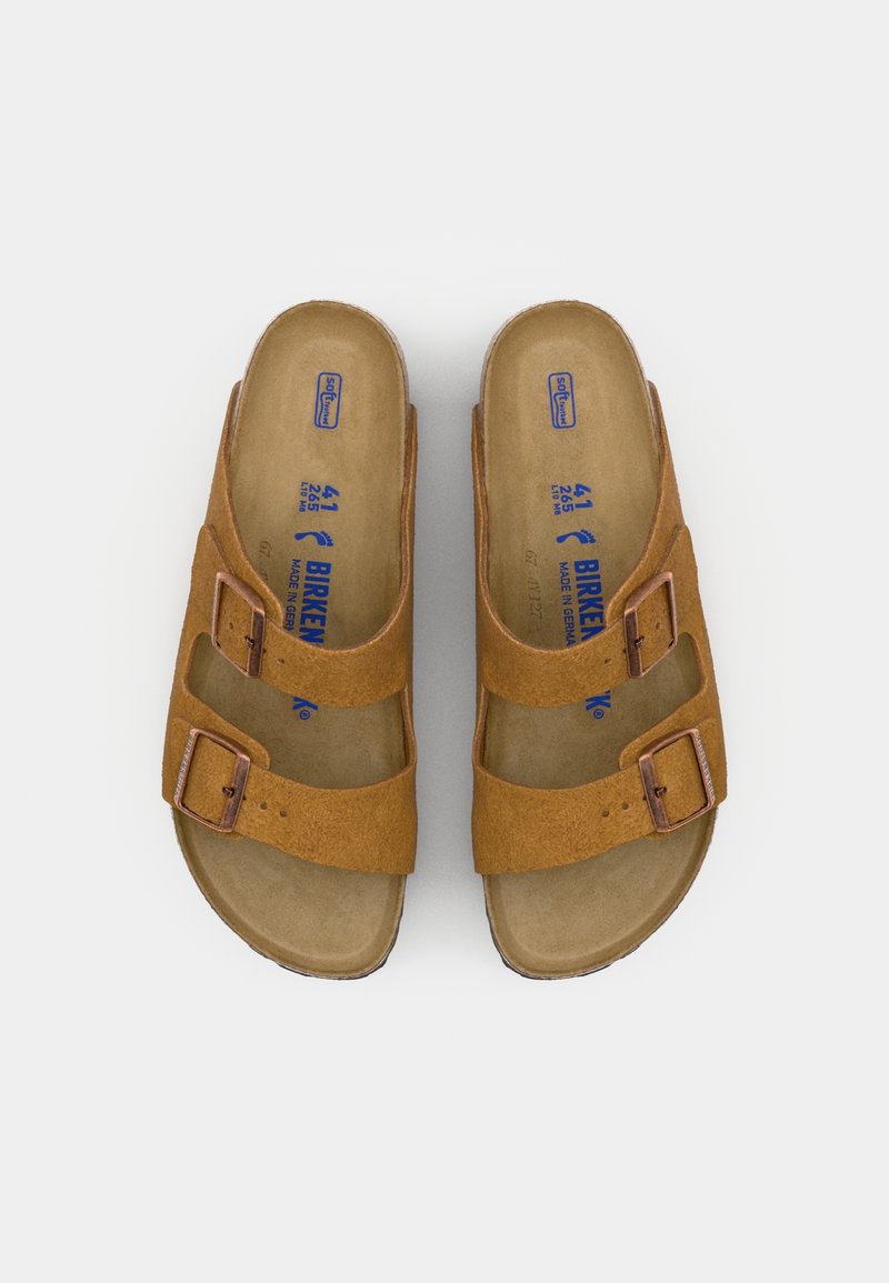 Sandales en suède marron avec deux brides réglables et boucles métalliques ; semelle intérieure ergonomique ; logo de la marque embossé ; design moderne à enfiler.
