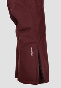 Pantaloni da sci impermeabili bordeaux con zip laterali e branding "STX 20.000". Caratterizzati da un tessuto leggero e una texture liscia.